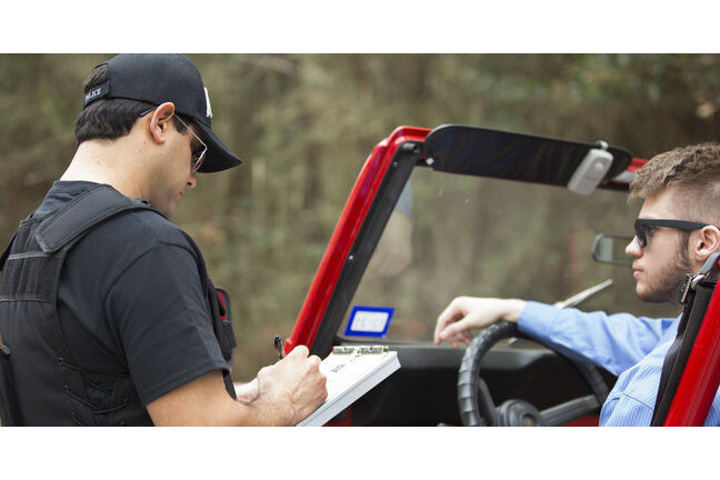 Man in a jeep getting a ticket